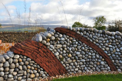 A curving stoned wall is the focus of this Cumbrian garden design.