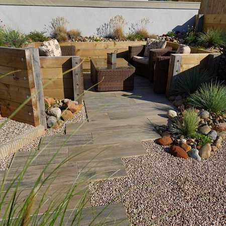 An upper Millboard composite wood deck and a lower sheltered ‘harbour’ area with feature groynes to reinforce the coastal garden theme.